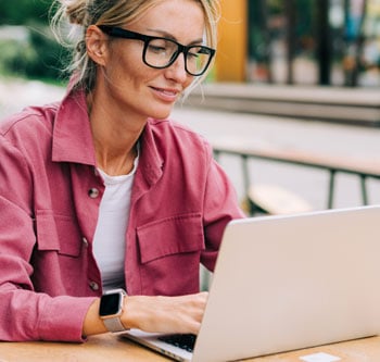 Woman in pink jacket on her computer