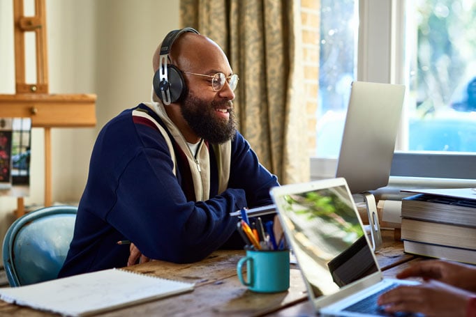 Man looking at his computer with headphones