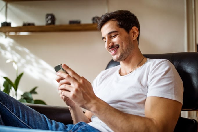 man smiling at his phone