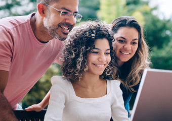 Girl and her parents looking at a computer