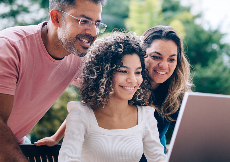 Girl and her parents looking at a computer